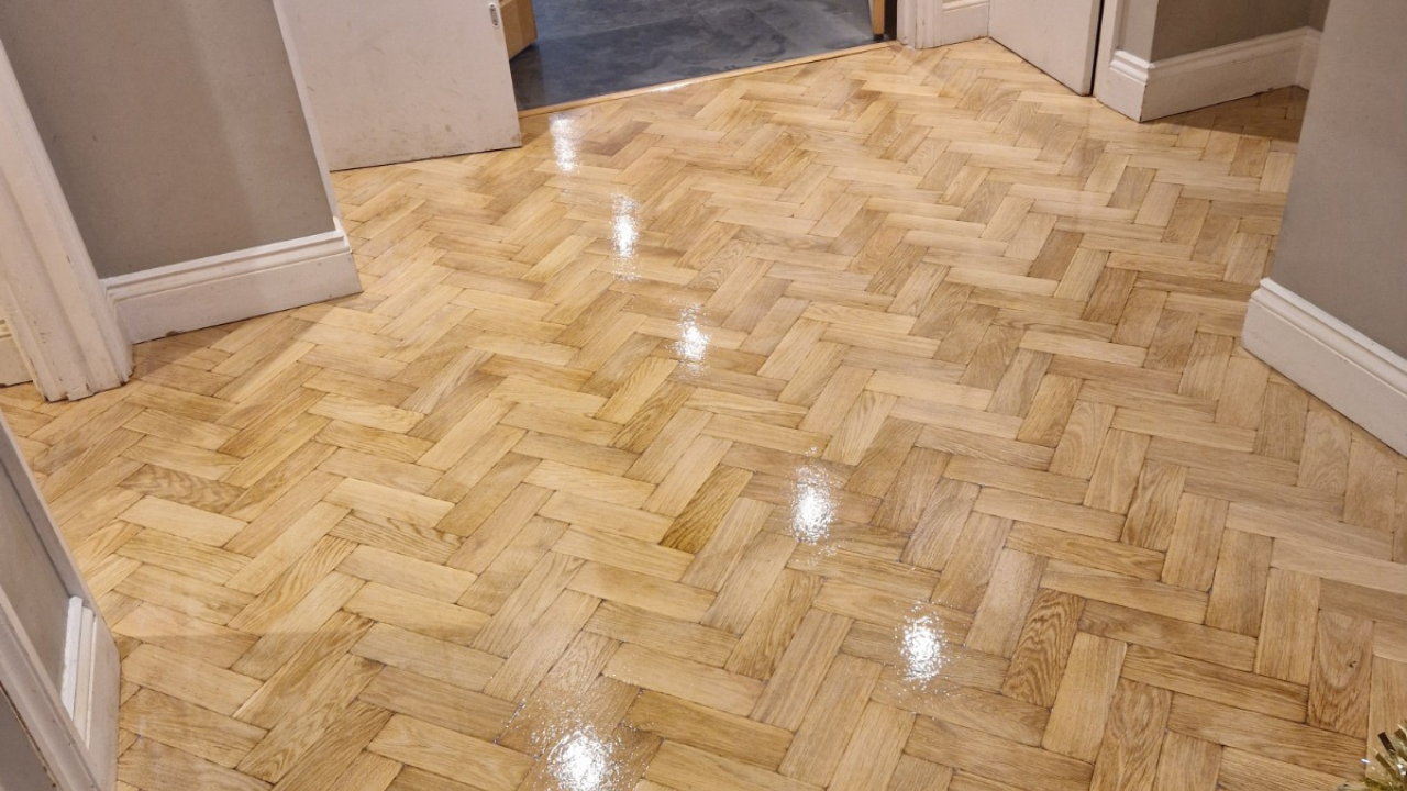 Wood Floor Sanding in eastbarnet on a light oak herringbone parquet hallway floor, showing a freshly lacquered, glossy finish after restoration.