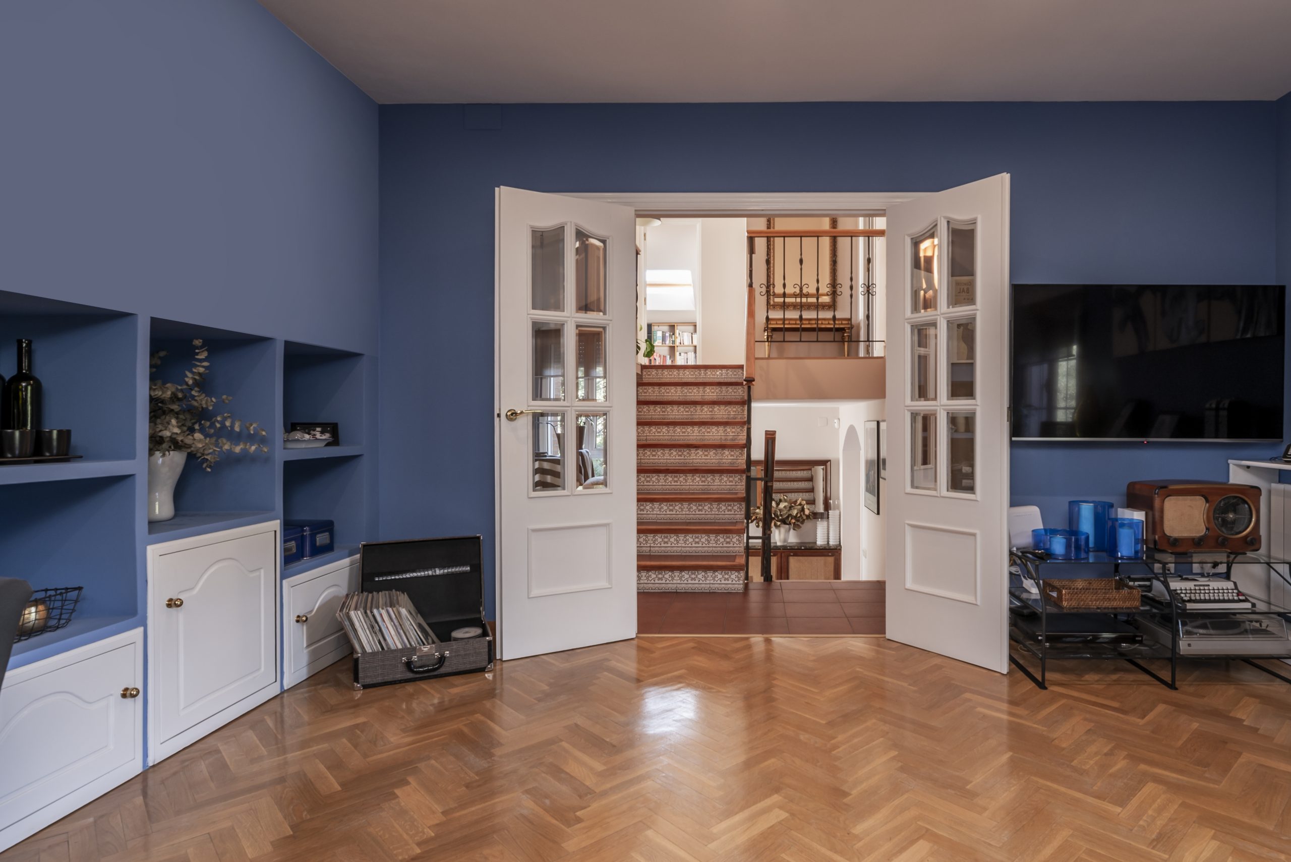 Wood Floor Sanding in eastbarnet on an oak herringbone parquet living room floor, shown beautifully restored beneath blue walls and white double doors.