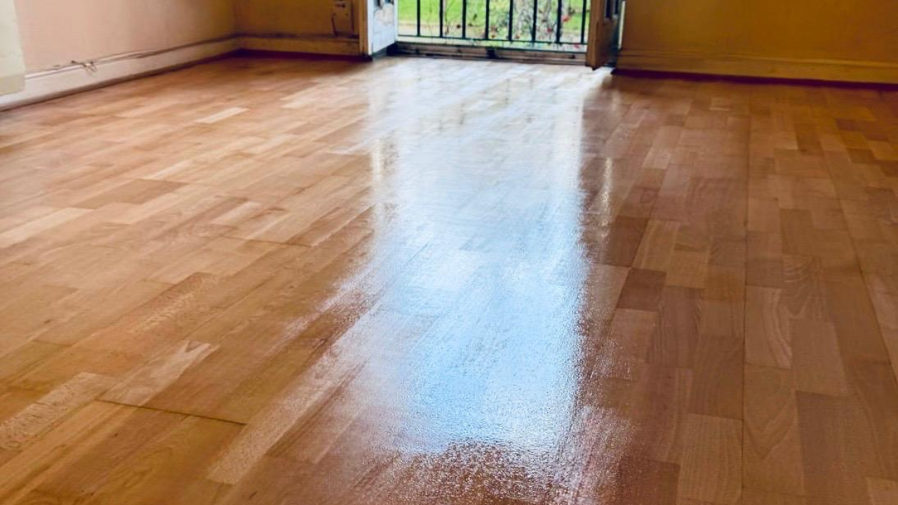 Hardwood Floor Sanding in eastbarnet on a beech block hardwood living room floor, freshly refinished with a glossy sheen near the patio doors.